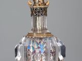 a glass perfume bottle with a gold and crystal decoration on it