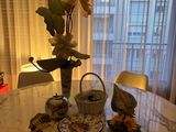 a table with a vase of flowers and a plate of food on it