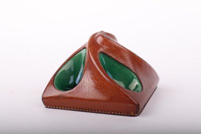 un étui en cuir marron contenant un verre vert