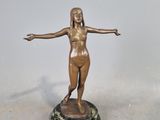 bronze statue of a woman standing on a pedestal with her arms outstretched