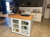 une cuisine avec un plan de travail en bois et des placards blancs