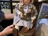 a woman that is sitting in a chair with a doll