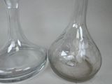 two glass vases sitting next to each other on a table