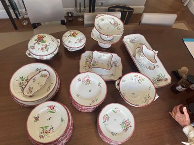 une femme assise à une table sur laquelle se trouvent de nombreuses assiettes et bols
