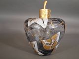 a glass bottle with a gold top and a gold cap