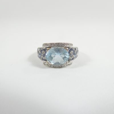 a white gold ring with a blue topaz and diamonds