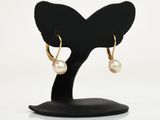 boucles d'oreilles créoles plaquées or ornées de perles, montées sur un support noir