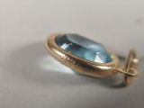 a close up of a blue topaz stone in a gold plated setting