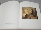 an open book with a picture of a woman sitting at a table