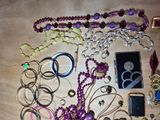 a lot of jewelry on a table with a cell phone