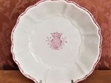 une assiette blanche ornée d'un motif rose, posée sur une table