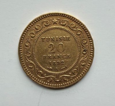 a close up of a gold coin on a white surface