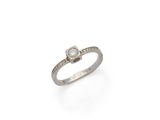 gros plan d'une bague en diamant sur une surface blanche