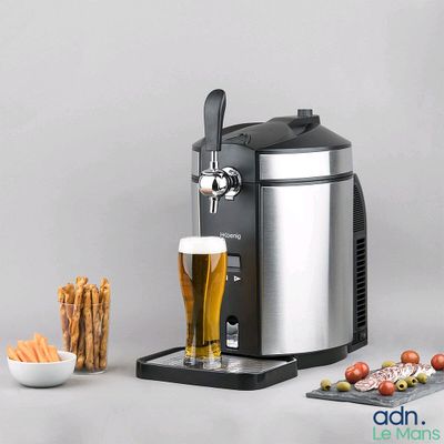 un gros plan d'un distributeur de bière avec un verre de bière à côté