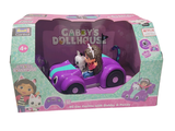une petite voiture violette avec un chien et un chat à l'intérieur, dans une boîte en carton