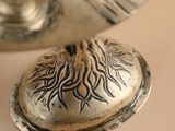 a silver container with a tree on it