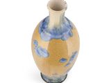 a blue and yellow vase sitting on a white surface