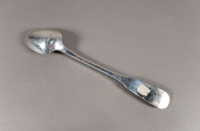une cuillère en argent avec un manche de cuillère sur une table