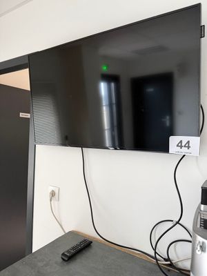 une télévision à écran plat fixée au mur dans la pièce