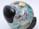 a glass pig with a sticker on it ' s head