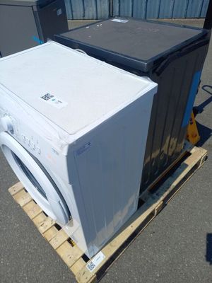 deux machines à laver posées sur une palette dans un parking