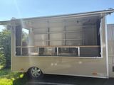 an image of a food truck parked in the grass