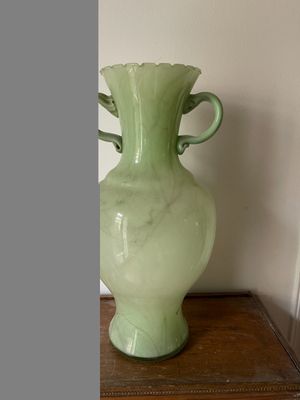 un vase vert posé sur une table en bois