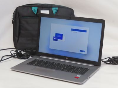 a laptop computer sitting next to a bag on a table