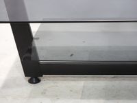 Table basse rectangulaire, le plateau en verre fumé reposant… (photo 2)