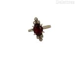 une image d'une bague avec une pierre rouge entourée de diamants blancs