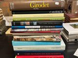 une pile de livres posée sur une table près d'un mur de briques