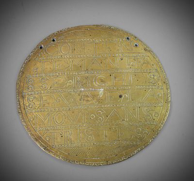 un gros plan d'une assiette en or sur laquelle figure une inscription