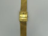 an image of a gold wrist watch on a white surface