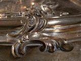 a silver plate with a clock on it on a table