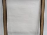an empty picture frame with a white background and a brown wood frame