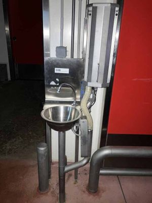 a metal sink in the corner of a room