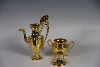 deux vases en or posés l'un à côté de l'autre sur une table