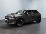 un SUV gris garé dans une pièce aux murs blancs
