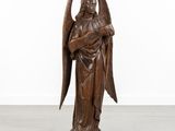 a wooden statue of an angel holding a cross