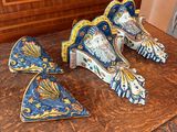 three pieces of blue and yellow pottery sitting on a wooden table