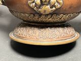 a large metal bowl with a handle on a table