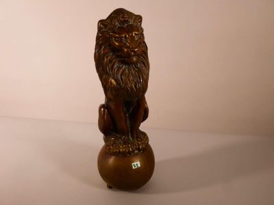 une statue représentant un lion assis sur une boule