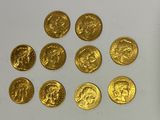 several gold coins are arranged in a circle on a white surface