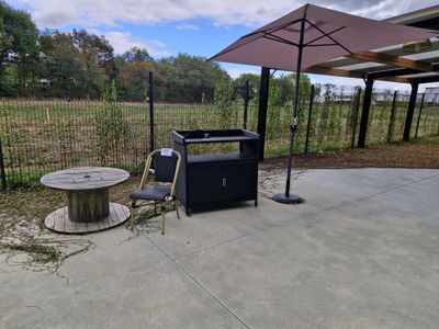 un barbecue avec une table et un parasol sur la terrasse