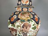 a large vase with a lid that has flowers and birds on it