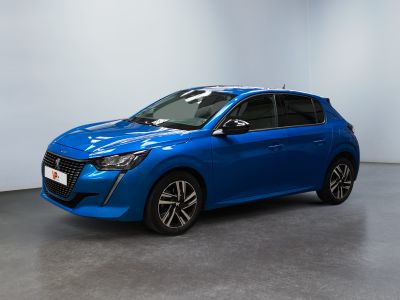 Une voiture bleue est garée dans une grande pièce aux murs blancs.