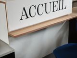 a sign that says accuell on the wall above a bar