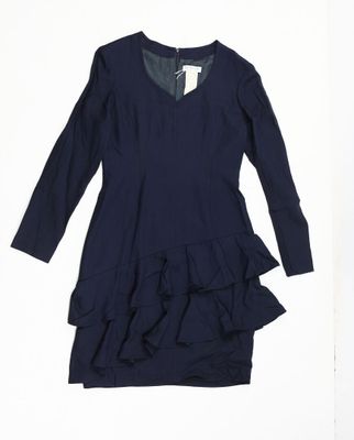 Cette robe a des manches longues et un ourlet à volants.
