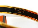 a close up of a gold bracelet with a black band