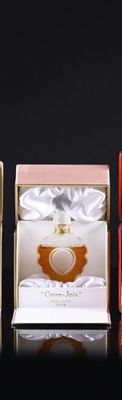 three boxes of perfumes are lined up on a black surface